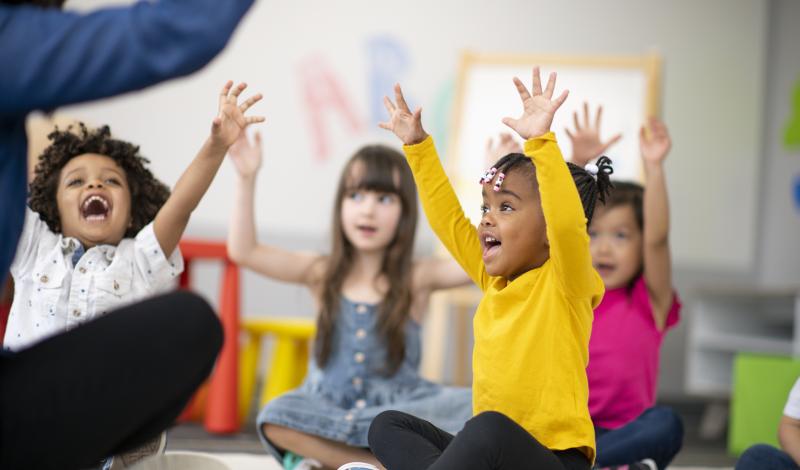 Kids with Hands Up in Classroom