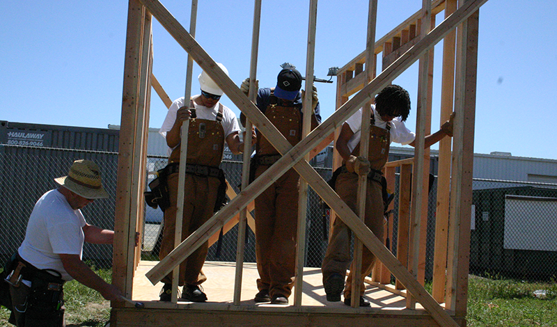 Trainees putting together framing on a house